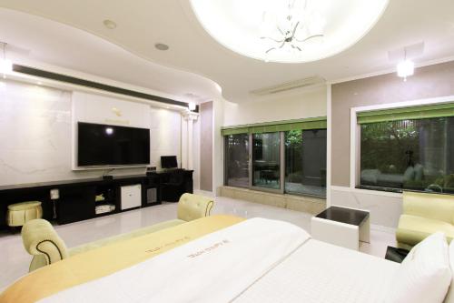 a dining room with a table and a tv at Renaissance Hotel Pohang in Pohang
