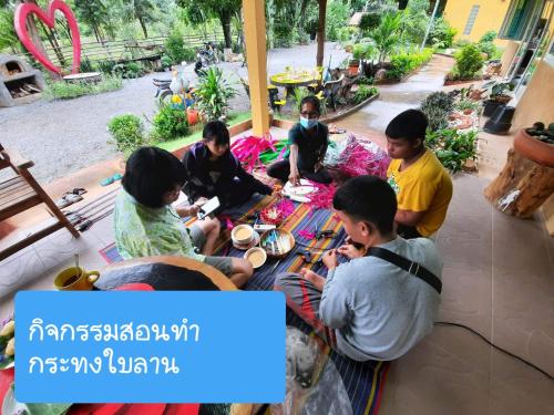 eine Gruppe von Menschen, die um einen Tisch sitzen in der Unterkunft Baandin resort in Sukhothai