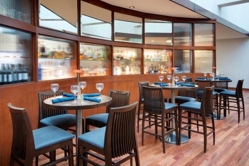 a restaurant with tables and chairs and windows at Hyatt Regency Dulles in Herndon