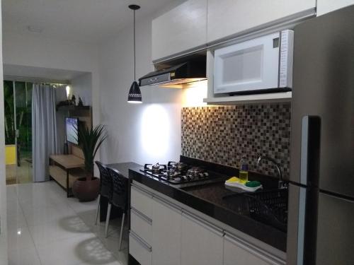 a kitchen with a black counter top and a microwave at Gravatá Winterville Residence in Gravatá