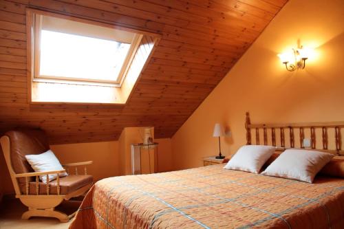 a bedroom with a bed and a window and a chair at Casa Rural la Comella in Barruera