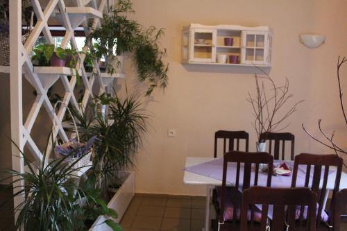 a dining room with a table and some plants at Zajazd Podlesie in Chociwel