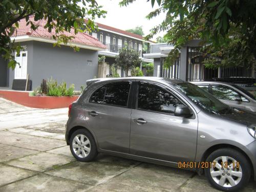 a silver car parked in front of a house at Aqilakost Gadog Puncak Bogor in Bogor