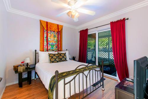 a bedroom with a bed and a window with red curtains at Quiet Mind Mountain Lodge, Retreat & Spa in Julian