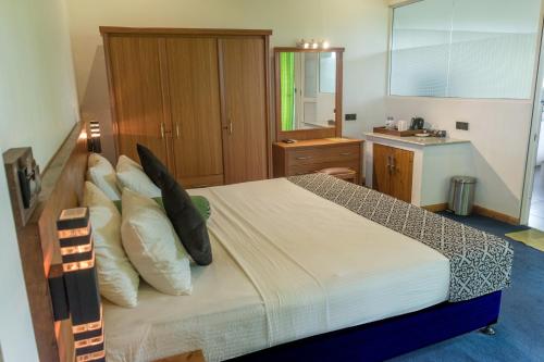 a bedroom with a large bed with pillows at Nice Place Resort in Dambulla