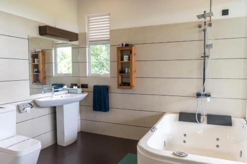 a bathroom with a sink and a toilet and a tub at Nice Place Resort in Dambulla