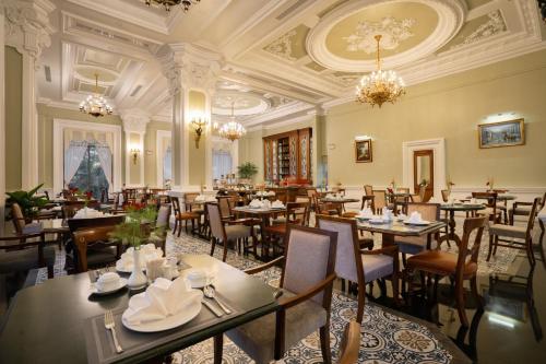 AVS Hotel Phu Quoc في فو كووك: مطعم به طاولات وكراسي وثريات