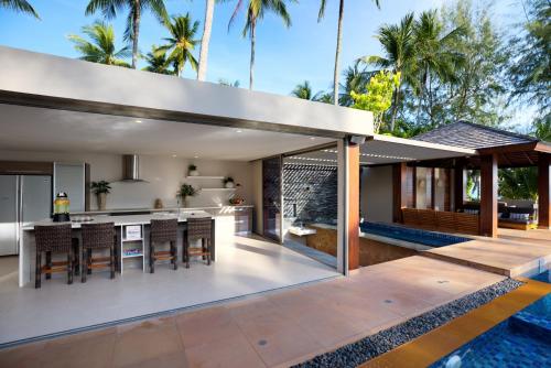 an open kitchen and dining area of a house with a swimming pool at Baan Kilee in Lipa Noi