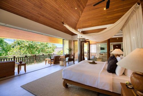 a bedroom with a large bed and a balcony at Baan Kilee in Lipa Noi