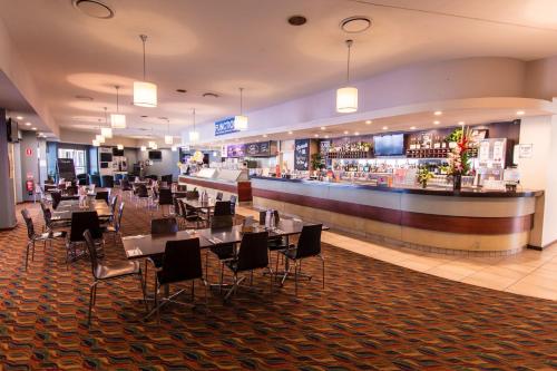 a restaurant with tables, chairs, and tables in it at Nightcap at Waterfront Hotel in Maroochydore