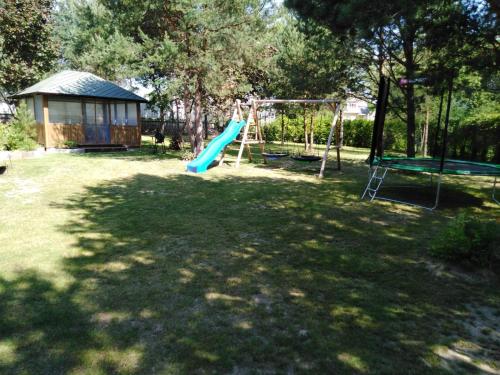 a playground with a slide in a yard at Mustvee Creek Cottage in Mustvee
