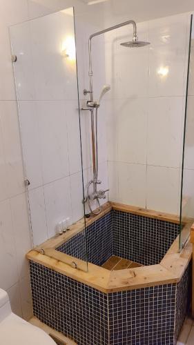 a bath tub with a shower in a bathroom at Charis Hotel in Incheon