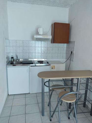 a kitchen with a table and chairs and a sink at Amaranthos Skiathos View in Megali Ammos