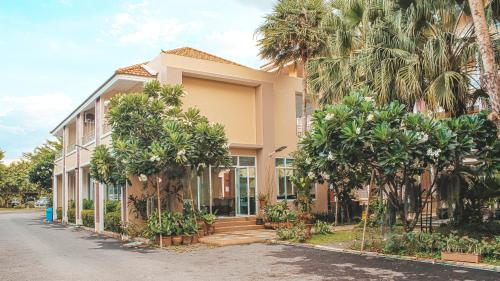 a building with palm trees in front of it at Nattidaplace Hotel Chiangmai in Chiang Mai