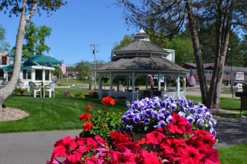 a gazebo with red and purple flowers in a park at Amber's Inn and Suites in Wisconsin Dells