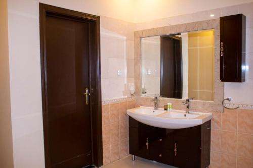 y baño con lavabo y espejo. en ال متعب سويتس الفلاح 1, en Riad