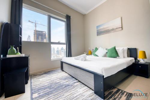 een slaapkamer met een groot bed en een groot raam bij Cozy 1BR at Bay Central 1 Dubai Marina by Deluxe Holiday Homes in Dubai