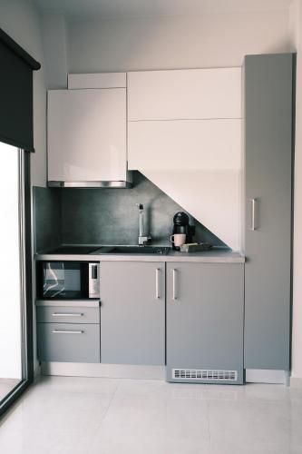 a kitchen with white cabinets and a sink at cobalt aqua in Iraklitsa