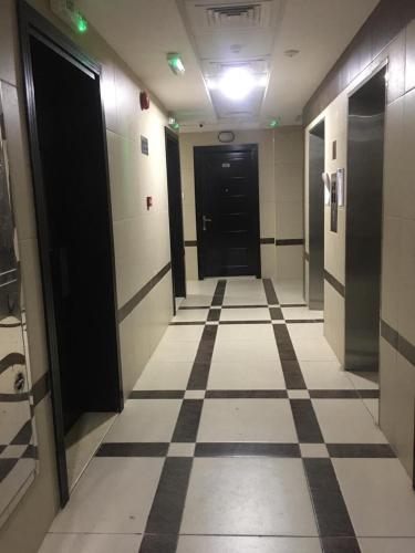 a hallway with black doors and a tiled floor at Affordable Bed Space in Fujairah in Fujairah