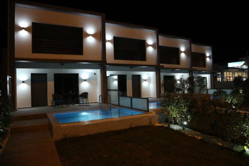 a house with a swimming pool in front of it at night at cobalt aqua in Iraklitsa