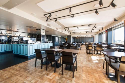 a restaurant with tables and chairs and a bar at Thon Partner Hotel Victoria Hamar in Hamar