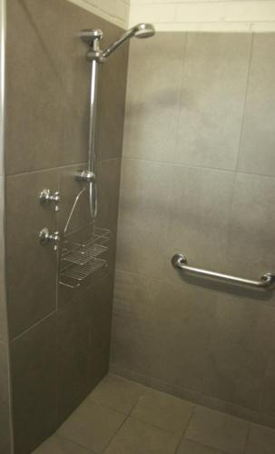 a shower stall in a bathroom with a glass door at The Plains Motor Inn in Gunnedah