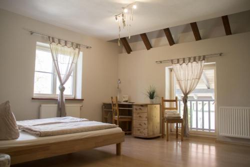 ラーベンスブルクにあるSchnyder Ranchのベッドルーム1室(ベッド1台、デスク、窓2つ付)
