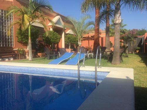 a swimming pool with a slide in front of a house at Chalet Martin in Chiclana de la Frontera