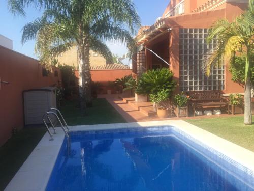 a swimming pool in front of a house at Chalet Martin in Chiclana de la Frontera
