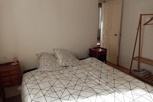 une chambre avec un lit avec une couette noire et blanche dans l'établissement Kermaravel, le petit manoir en bord de mer., à Saint-Pol-de-Léon