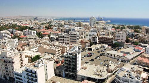 an aerial view of a city with buildings and the ocean at Jimmy's Suites in Larnaka