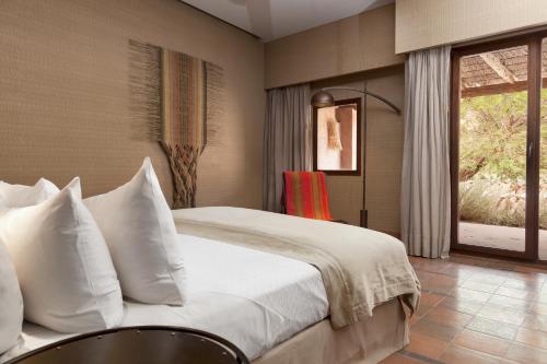 a bedroom with a large bed with white pillows at Nayara Alto Atacama in San Pedro de Atacama