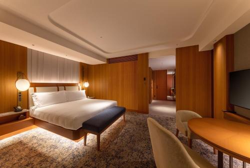 a bedroom with a bed and a television and a desk at InterContinental Yokohama Pier 8 by IHG in Yokohama
