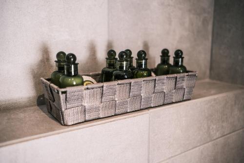 a basket filled with green bottles sitting on a ledge at cobalt aqua in Iraklitsa