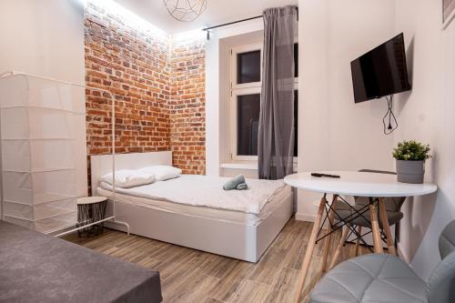 Kleines Zimmer mit einem Bett und einem Tisch in der Unterkunft Dream Aparts-Rewolucji 2 in Łódź