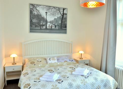 ein Schlafzimmer mit einem Bett mit zwei Nachttischen und zwei Lampen in der Unterkunft Apartmány Vila Mánička in Kácov