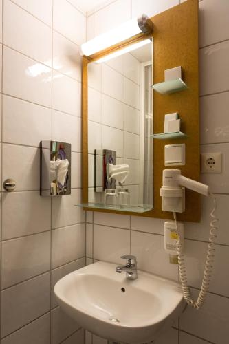 a bathroom with a sink and a mirror at Hotel Pegasus in Munich