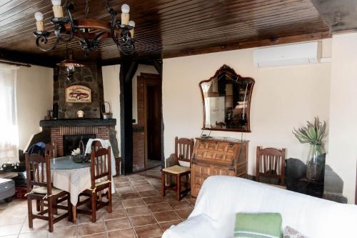 a living room with a fireplace and a table and chairs at Lanjarón Rural Apartamentos in Lanjarón