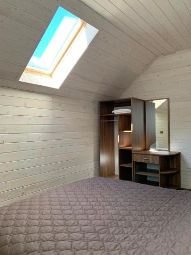 a attic bedroom with a bed and a skylight at готель Вікторія in Volovets
