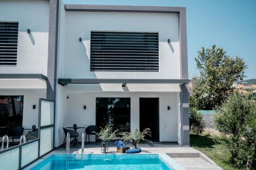 a villa with a swimming pool and a house at cobalt aqua in Iraklitsa