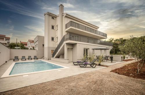 een huis met een zwembad ervoor bij Luxury Apartments Villa Lacrima in Šilo