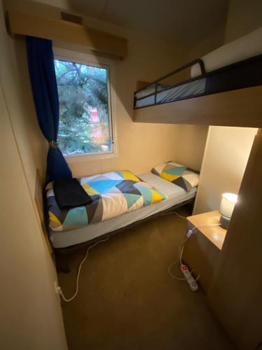 een kleine slaapkamer met een stapelbed en een raam bij Mobilný domček in Terchová