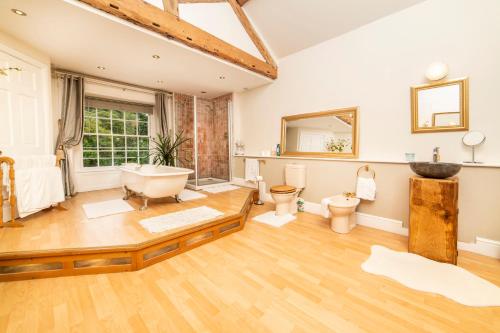 baño con bañera, 2 aseos y lavamanos en Self Catering Accommodation, Cornerstones, 16th Century Luxury House overlooking the River en Llangollen