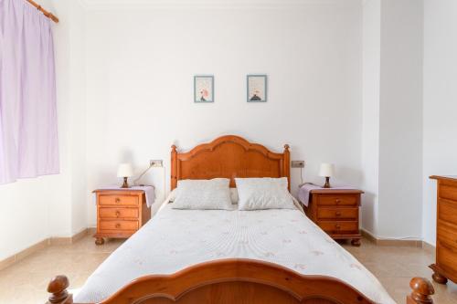 ein Schlafzimmer mit einem Holzbett und zwei Nachttischen in der Unterkunft Apartamento Valle de Abdalajis in Málaga