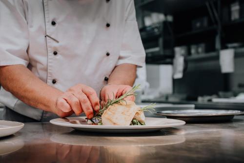 a chef preparing a plate of food on a counter at Weßner Hof Landhotel & Restaurant in Marquartstein