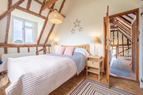 Ένα ή περισσότερα κρεβάτια σε δωμάτιο στο Stylish rural cottage with views over fields and the River Stour - The Granary
