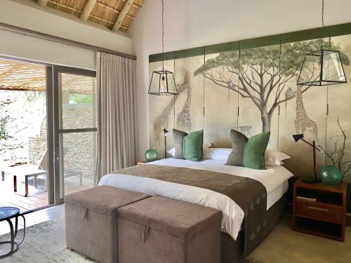 a bedroom with a bed with a mural of a giraffe at Simbavati Camp George in Klaserie Private Nature Reserve