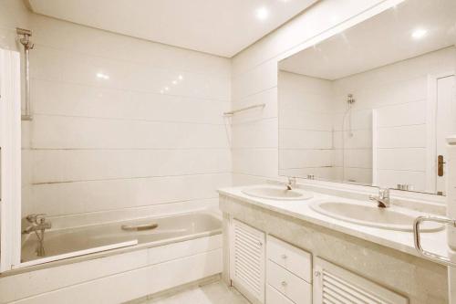bagno con 2 lavandini, vasca e specchio di Apartamento entre Marbella y Estepona a Estepona
