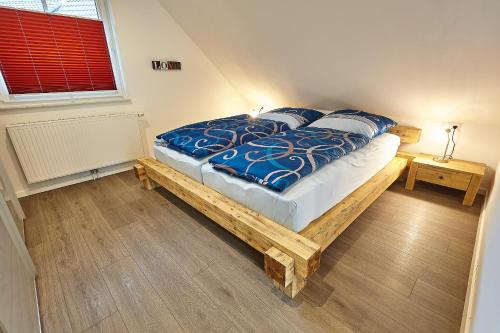 a bedroom with a bed with blue comforter and pillows at Exklusive Ferienwohnung auf dem Romanshof - Naturidylle pur - Nebengebäude in Loßburg