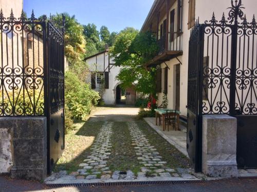 an entrance to a house with an iron gate at Gîte Vanakam 3 étoiles- jolie maison béarnaise 9 personnes avec piscine in Sault-de-Navailles